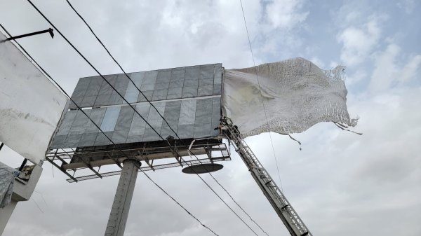Retiran lona de espectacular tras fuertes vientos en la frontera